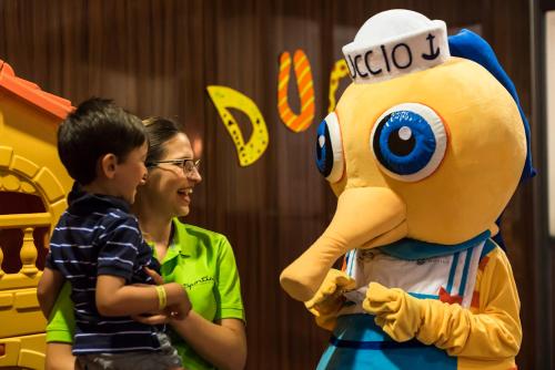 a woman and a child standing next to a mascot at Hotel Sporting in Rimini