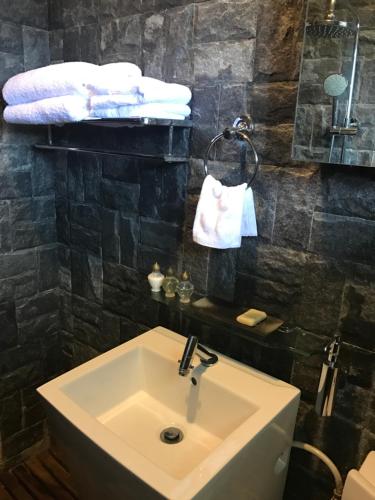 a bathroom with a sink and a toilet and towels at Mesilau Mountain Retreats in Kundasang