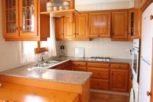 a kitchen with wooden cabinets and a granite counter top at Can Quilis in Pontós