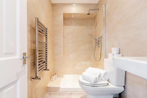 a bathroom with a toilet and a shower and a sink at Bright & Spacious 4beds home - Kensington High Street-Olympia in London