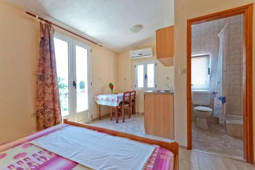 a bedroom with a bed and a bathroom with a sink at Apartments Jerković in Stari Grad