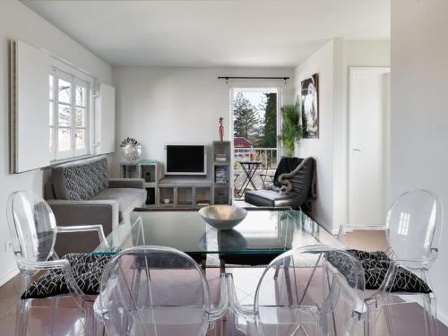 a living room with a glass table and chairs at Carcavelos Beach&Bike House (view, parking, wi-fi) in Carcavelos