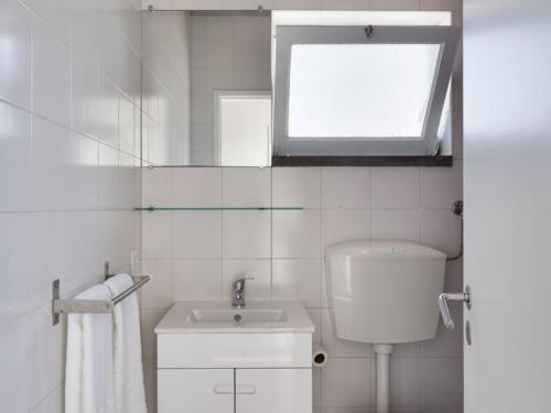 a bathroom with a toilet and a sink and a window at Carcavelos Beach&Bike House (view, parking, wi-fi) in Carcavelos