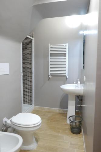 a white bathroom with a toilet and a sink at Opera Boutique Rooms in Monreale