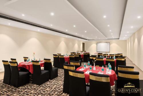 a conference room with tables and chairs and a screen at Ramada Neemrana in Neemrana