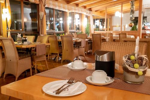 a restaurant with a table with plates and utensils on it at Landhotel Aschenbrenner in Freudenberg