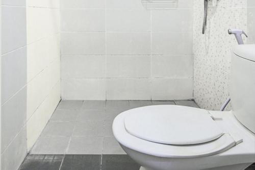 a white bathroom with a toilet and a sink at RedDoorz at Siwalankerto Surabaya in Surabaya
