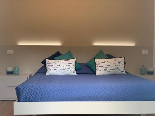 a bed with blue sheets and pillows in a room at San Giorgio La Litoranea in La Spezia