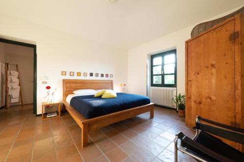 a bedroom with a large bed with a blue bedspread at La Fornace in Alessandria