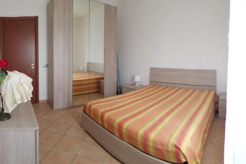 ein Schlafzimmer mit einem Bett mit einer gestreiften Decke in der Unterkunft The Royal Home (Reggia di Caserta / università / centro in 5min) in Caserta