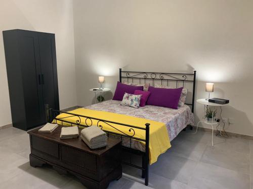 um quarto com uma cama grande e almofadas roxas em Aus Holiday Catania em Catânia
