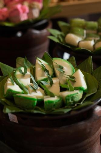 a plate of food with green vegetables on a table at Hotel Santika Gresik in Gresik