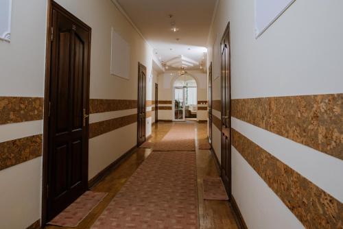 a corridor in a building with brown and white walls at Villa Viktoriya Hotel in Truskavets