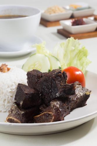 a plate of food with rice and meat and vegetables at Hotel Santika Gresik in Gresik
