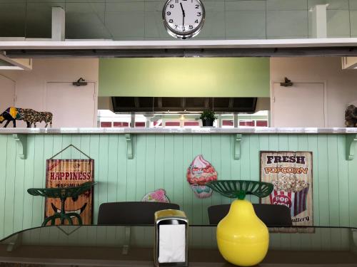 a restaurant with a clock on the wall and a yellow vase at Le 81 HOTEL in Castres