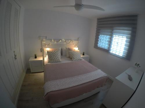 een slaapkamer met een bed met verlichting bij Cambrils Regata Apartamento junto el mar in Cambrils