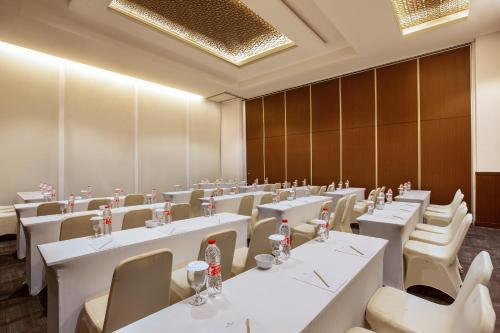 a conference room with white tables and chairs at Hotel Santika Gresik in Gresik