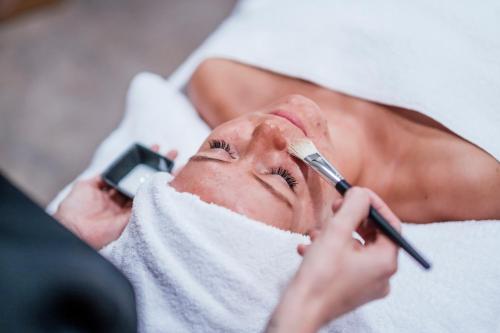 a man laying on a bed while applying a eyebrow shaderphalt at Pernilla Wiberg Hotel in Idre