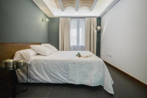 ein Schlafzimmer mit einem weißen Bett und einem Fenster in der Unterkunft Artal by CASALEA in Morella