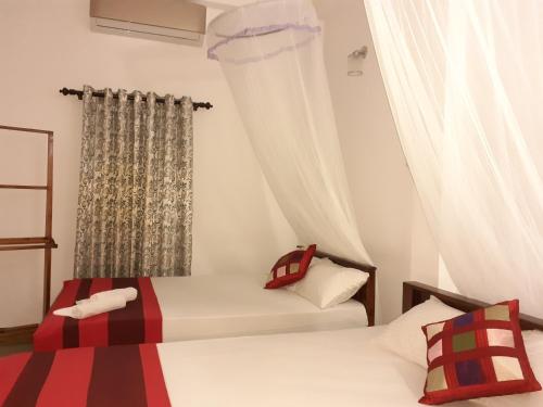 una camera da letto con due letti e una finestra di Golden Pearl Safari Villa a Udawalawe