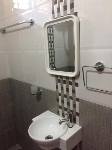 a bathroom with a sink and a mirror on the wall at Nimmu Guest House & Restaurant Gokarna in Gokarna