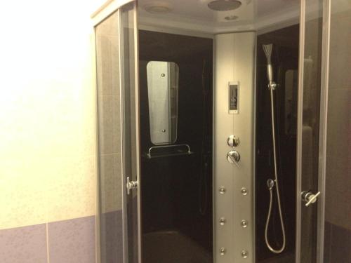 een deur naar een douche met een spiegel erin bij Royal Hotel in Charkov