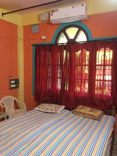 a bed with two pillows in front of a window at Nimmu Guest House & Restaurant Gokarna in Gokarna