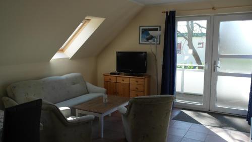 a living room with a couch and a tv and a table at Fewo Ückeritz in Ueckeritz