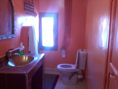 a bathroom with a sink and a toilet and a window at Hotel Rochers Peints in Tafraoute