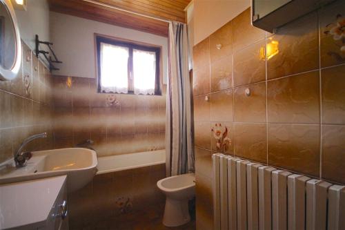 une salle de bain avec un lavabo et des toilettes et une fenêtre dans l'établissement Triolet 1, à Morzine