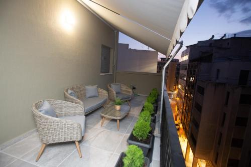 a balcony with chairs and tables on a building at Still Athens in Athens