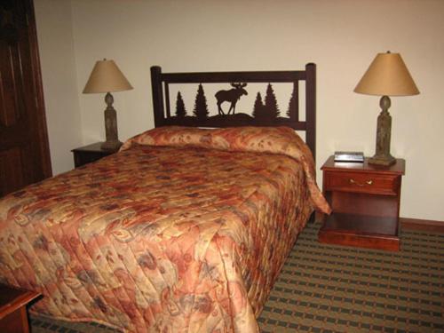 um quarto de hotel com uma cama e duas mesas de cabeceira em Sunburst Condominiums, a VRI resort em Steamboat Springs