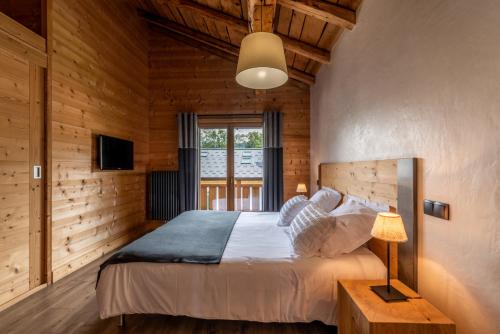 een slaapkamer met een bed in een houten kamer bij Chalet l'Arolle in Les Gets