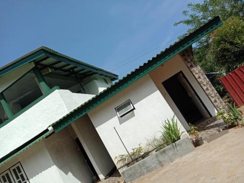 a white house with a green roof at The Misty Mountain Guest House in Haldummulla