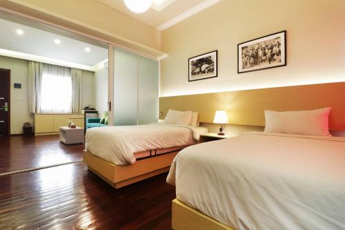 Habitación de hotel con 2 camas y ventana en Pejaten Valley Residence, en Yakarta