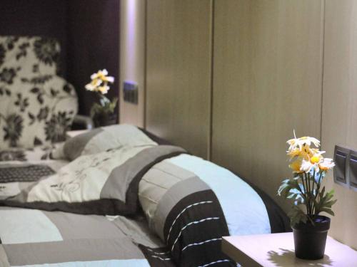 Un dormitorio con una cama y una mesa con flores. en BARCELONA GOTIC Guesthouse, en Barcelona