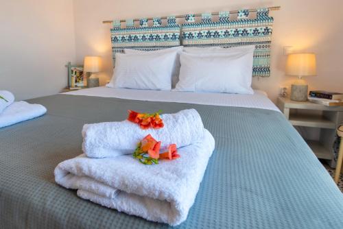 a bedroom with a bed with towels and flowers on it at Aglaia V Studio in Gaios