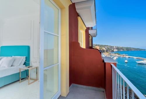 a balcony with a bed and a view of the water at Hotel Lorelei Londres in Sorrento
