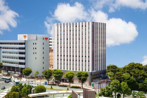 un edificio blanco alto con muchas ventanas en Kitanoniwa The Kuretakeso en Hamamatsu