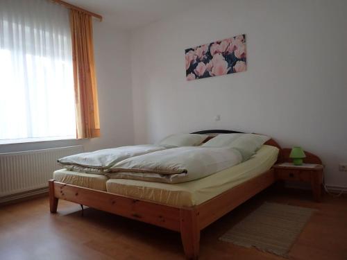 ein Schlafzimmer mit einem Bett mit einem Holzrahmen in der Unterkunft Gemütliche Ferienwohnung in der Lüneburger Heide in Sprakensehl