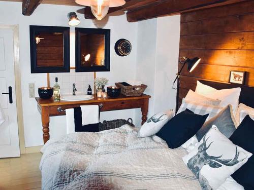 Schlafzimmer mit einem Bett, einem Schreibtisch und einem Waschbecken in der Unterkunft Linne-Cottage in Willingen
