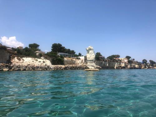 a view from the water of a rocky island at La Caletta di Afrodite in Calabernardo