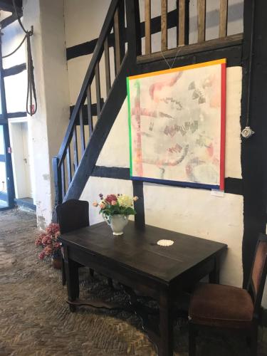 a table with flowers on it next to a staircase at Haus Buuck - Appartement in Rüthen