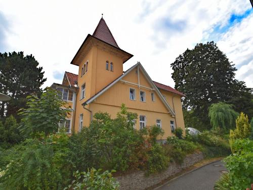 バート・ズダーオーデにあるModern holiday home in a listed villa with a view of Bad Suderodeの道路脇の塔のある黄色い建物