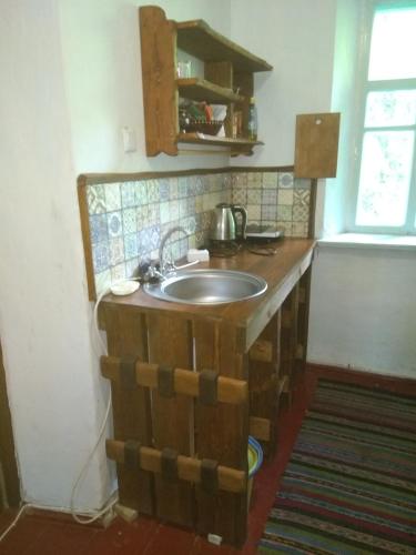 a kitchen with a wooden counter with a sink at Садиба "БІля Виру" in Buki