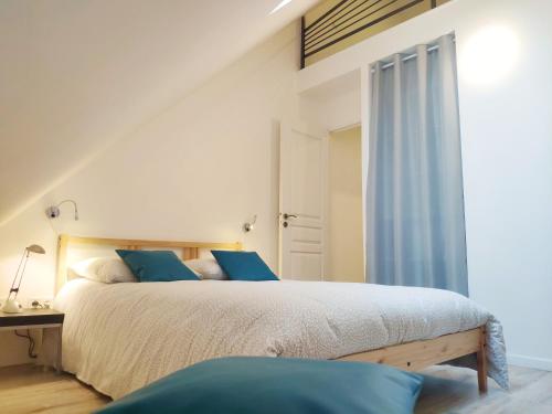 a bedroom with a large bed with blue pillows at Maison de ville centre Nogent le Rotrou in Nogent-le-Rotrou