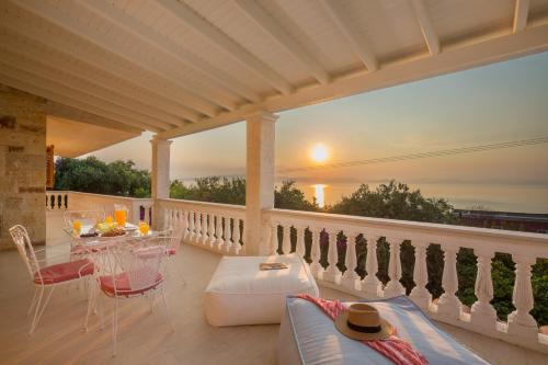 patio con mesa y sillas en el balcón en Ionian Garden Villas - Villa Pietra en Benitses