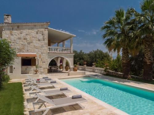 a villa with a swimming pool and lounge chairs at Ionian Garden Villas - Villa Pietra in Benitses