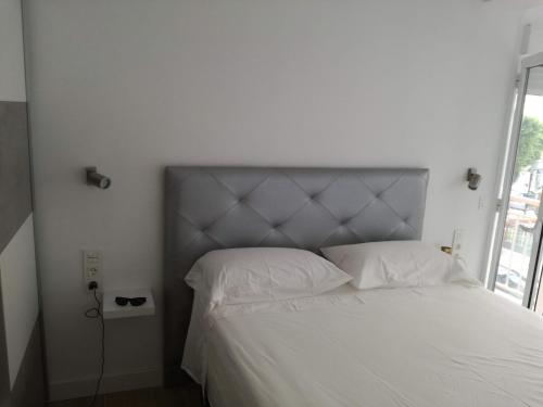 1 dormitorio con cama blanca y ventana grande en Zapillo, en Almería