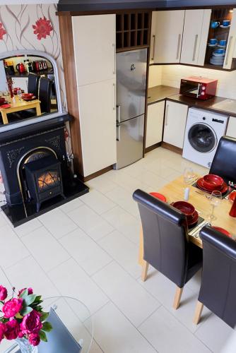 a kitchen with a table and a fireplace in it at Henry Court Townhouse in Kenmare